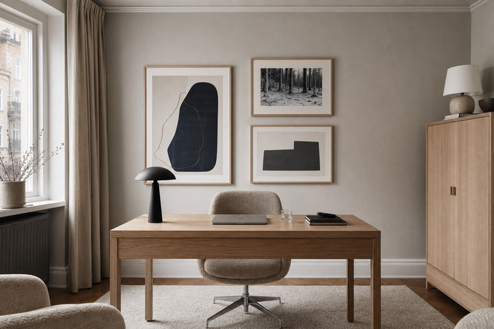 Nordic editorial calm home office featuring polished, camera-ready art arrangement behind a simple oak desk