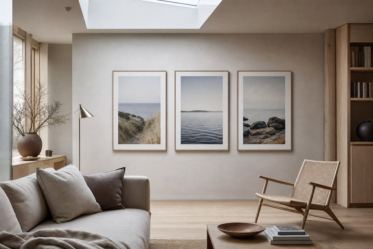 Nordic editorial Nordic coastal or travel-inspired sitting room featuring framed art that evokes place, horizon and travel memories