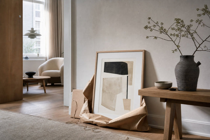 Nordic editorial quiet Nordic entry or living room featuring beautifully wrapped framed art presented as a thoughtful gift beside a finished interior vignette